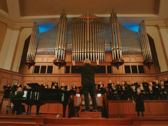 Wide view of the Johns Creek Chorale led by Dr. Nathan Frank, performing in front of an audience.