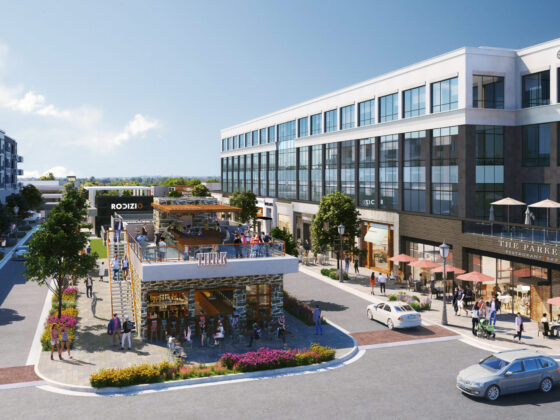 A rendered image of Medley at Johns creek with buildings, people, cars and blue sky.